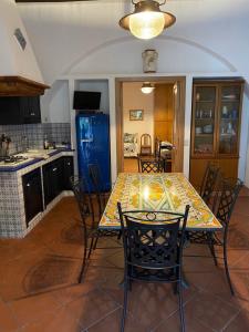 uma cozinha com uma mesa com cadeiras e um frigorífico azul em Casa Schicciola em Stromboli