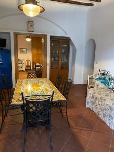 una sala da pranzo con tavolo, sedie e letto di Casa Schicciola a Stromboli