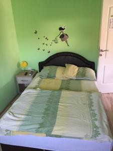 um quarto verde com uma cama com pássaros na parede em Oaza Mira Vrdnik em Vrdnik