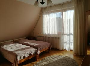 two beds in a room with a large window at Pokoje Ewka in Czarna Góra