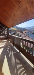 a balcony with a wooden railing and a view of buildings at L'Ourson skis aux pieds in Valmeinier +14 photos