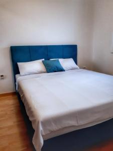 パレにあるApartman Pahuljaの青いヘッドボード付きの大型ベッド1台が備わる客室です。 +26枚の写真