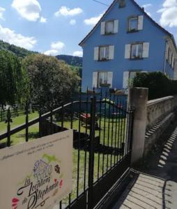 a building with a gate and a sign in front of it at Les Locations de Stéphanie ,gîte L'Arbre Vert in Sondernach