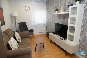 a living room with a couch and a flat screen tv at Piso centrico y moderno en Logroño Vivienda de uso Turistico in Logroño