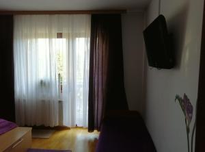 a living room with a window and a television at Pokoje Ewka in Czarna Góra