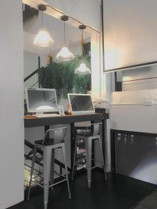 a kitchen with a table and a laptop on it at 3Howw Hostel @ Sukhumvit 21 in Bangkok