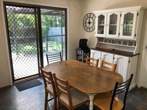 a dining room with a wooden table and chairs at Bowral Bungalow in Bowral