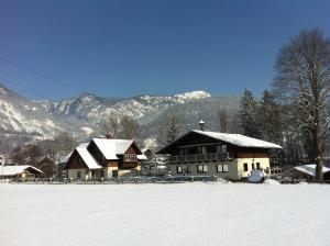 a house in the snow with mountains in the background at Etschbacher in Haus im Ennstal