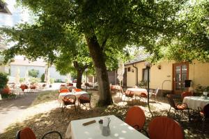 a restaurant with tables and chairs under a tree at Hotel Krone Straßdorf in Schwäbisch Gmünd