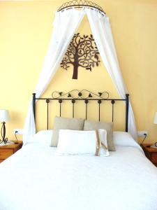 a bed with a canopy with a tree on it at Casa Rural El Boyo in Mingorría