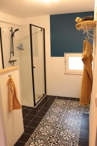 een badkamer met een douche en een tegelvloer bij Kade10Buren in Buren