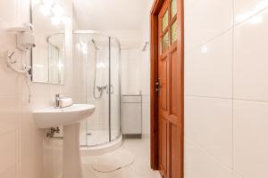 a white bathroom with a sink and a shower at 9 Sił Murowany Dom in Bukowina Tatrzańska