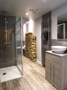 a bathroom with a glass shower and a sink at The George at Nunney in Frome