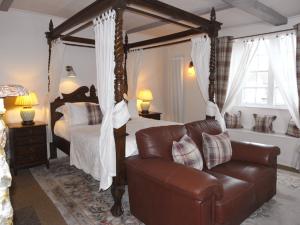 a bedroom with a canopy bed and a couch at The George at Nunney in Frome