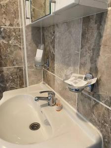 ein Badezimmer mit einem weißen Waschbecken und einem Spiegel in der Unterkunft Podrinjski san in Loznica