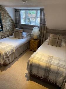 a bedroom with two beds and a window at The George at Nunney in Frome