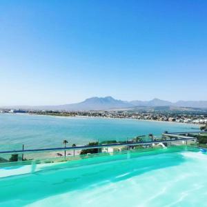 vistas a la playa desde el techo de un edificio en GORDON's SHORE LUXURY APARTMENTS - Solar Powered en Gordonʼs Bay