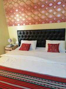 a bedroom with a large white bed with red pillows at Hamoudah Hotel in Amman