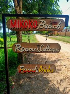 un cartel que dice mikoto Beach Ronos y pollos comida y bebidas en Mikoko Beach & Cottages, en Bagamoyo