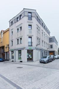 a white building with cars parked in front of it at Apartamenty Grodowa 2 in Gliwice