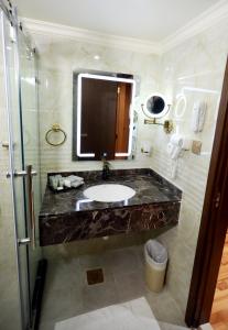 a bathroom with a sink, toilet, and shower stall at Ras Al Khaimah Hotel in Ras al Khaimah