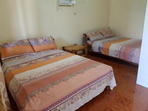 een kamer met 2 bedden en een stoel. bij R&;S Restplace Resort in Matabungkay