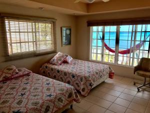 a bedroom with two beds and windows with a view of the ocean at CafeGourmetPtaCorona in San Carlos