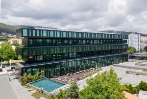 un edificio de oficinas con una piscina delante en Axis Viana Business & SPA Hotel, en Viana do Castelo