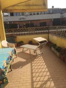 un patio con tavolo e panca sul balcone di Appartamento Zia Gesina a Lido di Ostia