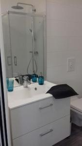 Baño blanco con lavabo y espejo en Studio rénové et équipé 2 personnes Le canardeau, en Ancy-sur-Moselle