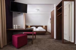 a bedroom with a bed and a dresser at Boutique Hotel Societe in Baden-Baden
