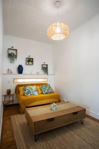 sypialnia z żółtym łóżkiem i stolikiem kawowym w obiekcie La tête Ault - Une expérience unique en bord de Mer w mieście Ault