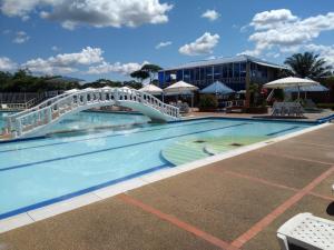 a swimming pool with a bridge in a hotel at Hotel Campestre Kosta Azul in Villavicencio
