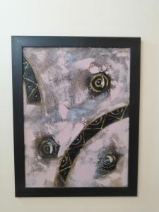 a painting of eyes on a white wall at Hamoudah Hotel in Amman