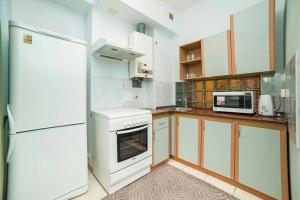 uma cozinha com electrodomésticos brancos e um frigorífico branco em Солнечные апартаменты на Крещатике em Kiev
