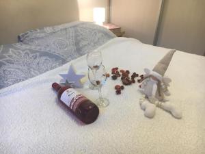 a bottle of wine and a glass on a bed at Apartman Lara,Zlatibor in Zlatibor