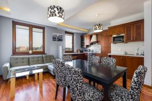 cocina y sala de estar con mesa y sillas en Sleepway Apartments- Szyperska en Poznan