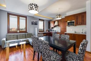 a kitchen and living room with a table and chairs at Sleepway Apartments- Szyperska in Poznań