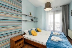 1 dormitorio con 1 cama con una pared colorida en Sleepway Apartments- Szyperska, en Poznan