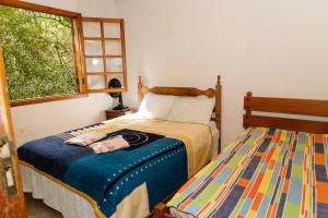 A bed or beds in a room at Chalés do Beto em Macacos