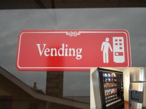 una señal roja para una máquina expendedora en una tienda en Red Carpet Inn Brooklawn en Brooklawn