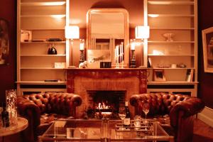 a living room with two leather couches and a fireplace at Le Chai in Condom