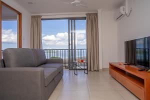 a living room with a couch and a flat screen tv at Kolibri Holiday Apartments in Victoria