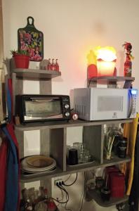 a microwave sitting on top of a shelf at Bed&Potato Studio Ilha Grande - Casa inteira para até 4 pessoas in Abraão