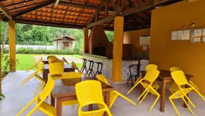 une salle à manger avec des chaises jaunes et une table dans l'établissement RIVIERA DE SÃO LOURENÇO, à Riviera de São Lourenço