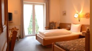Cette chambre comprend 2 lits et une fenêtre. dans l'établissement Waldhotel Twiehaus Garni, à Lübeck
