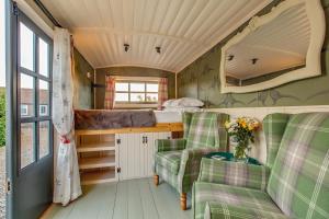 una habitación con 2 sillas y 1 cama en una casa pequeña en The Covey en Felbrigg