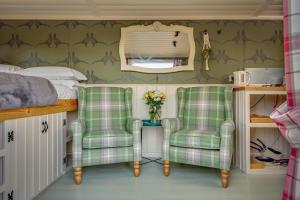 - une chambre avec deux chaises vertes et un lit dans l'établissement The Covey, à Felbrigg