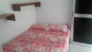 um quarto com uma cama com uma colcha vermelha e branca em JASMIM em São Paulo
