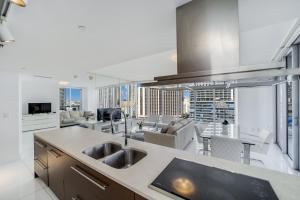 a kitchen with a sink and a living room at Icon Brickell Miami in Miami
